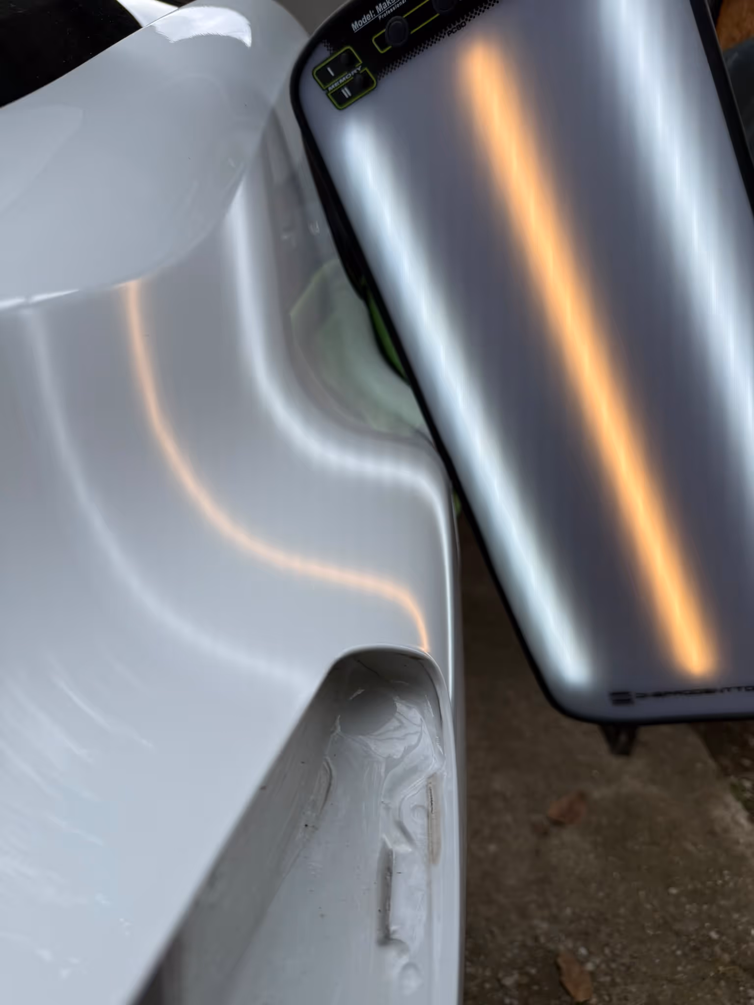 Îndoitură pe aripă reparată sub lampa PDR — după reparație